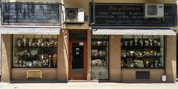 Frente de La Casa de las Copas en Tte. Gral. Perón 1306, con las dos vidrieras llenas de copas y trofeos